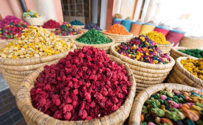 Colorful dried flowers and herbs displayed in woven baskets at a traditional Moroccan market