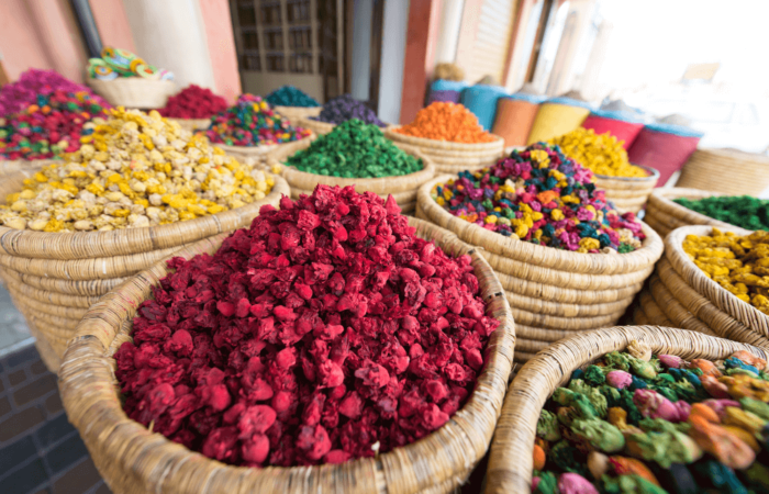 Colorful dried flowers and herbs displayed in woven baskets at a traditional Moroccan market