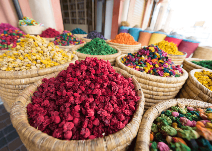 Colorful dried flowers and herbs displayed in woven baskets at a traditional Moroccan market