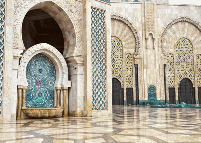 Traditional Moroccan courtyard with ornate arches blue mosaics and polished stone floors